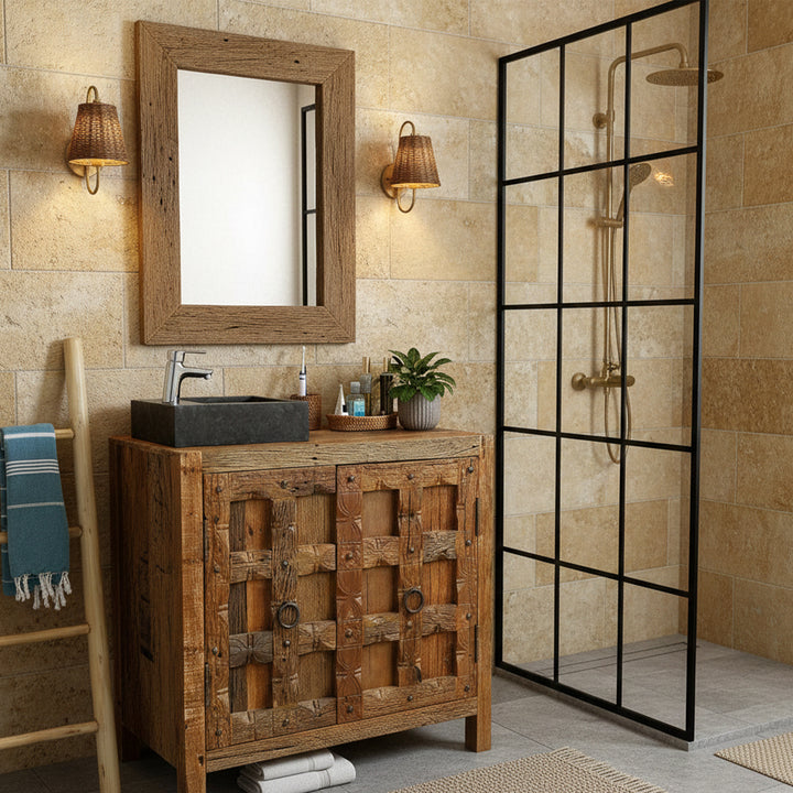 Angular Washbasin Made of stone with a dark surface on a rustic wooden washbasin in the warm bathroom, combined with chrome-plated fittings, a wooden mirror and a black shower enclosure