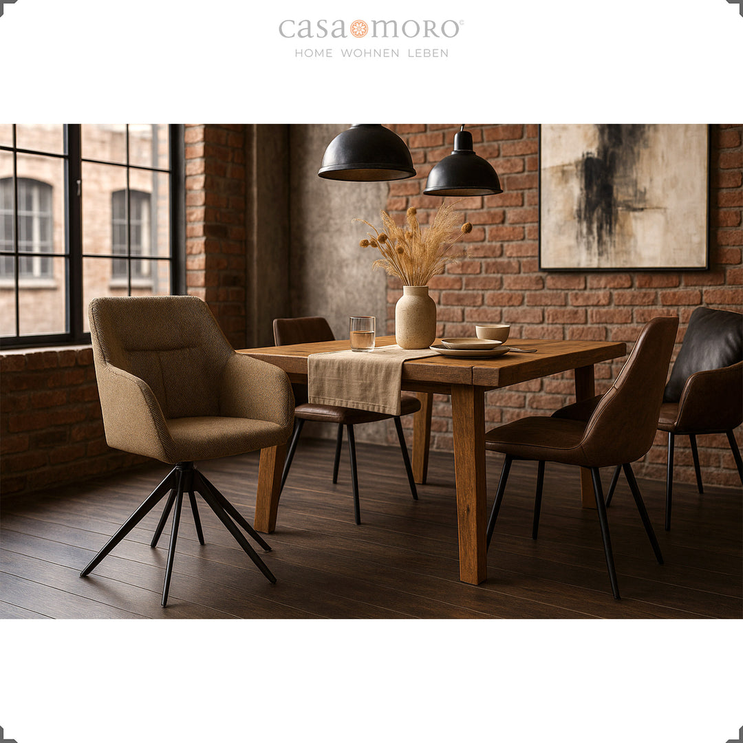 360° rotating upholstered chair with armrests in brown at a wooden table in a modern dining room with a brick wall and black pendant lights