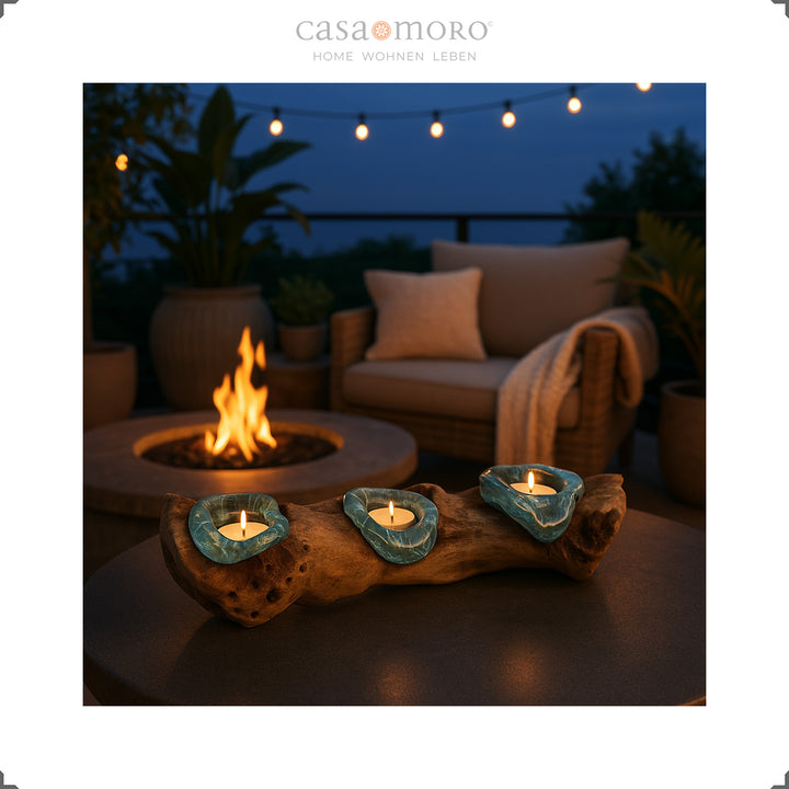 Glass and burl wood tealight holder on a patio at dusk surrounded by fire pit and boho outdoor decor