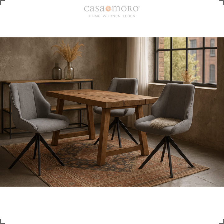 Three 360° rotating dining room chairs in gray with a black metal frame around a wooden table in a modern loft ambience with carpet and decoration