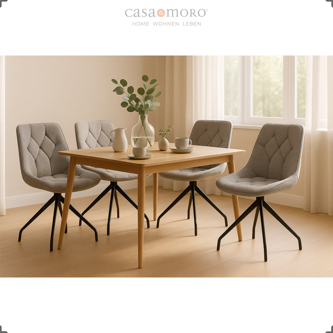 Four gray dining chairs with 360° swivel function and black metal frame - bright dining area with wooden table and natural decoration