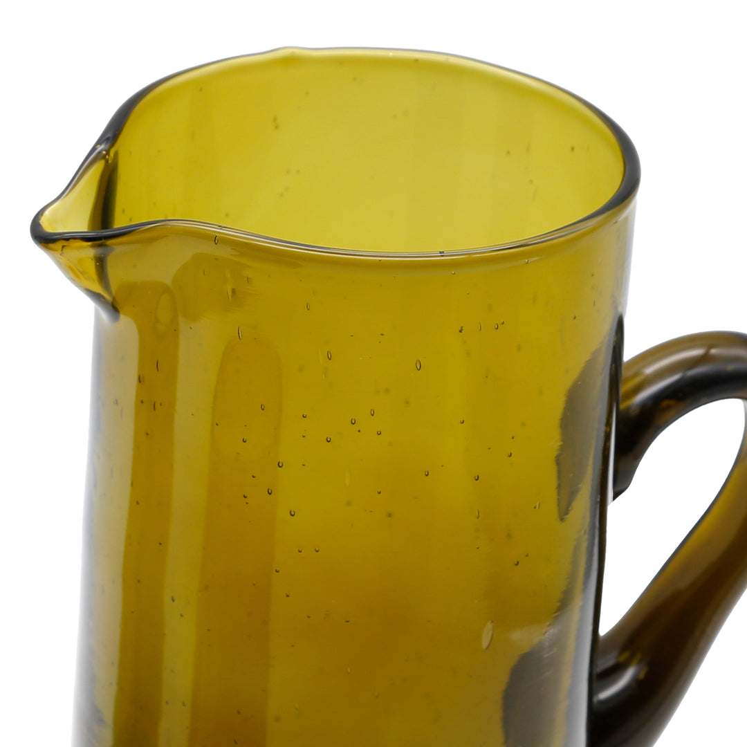 Carafe made of honey-colored glass with a fine structure and elegant pouring shape