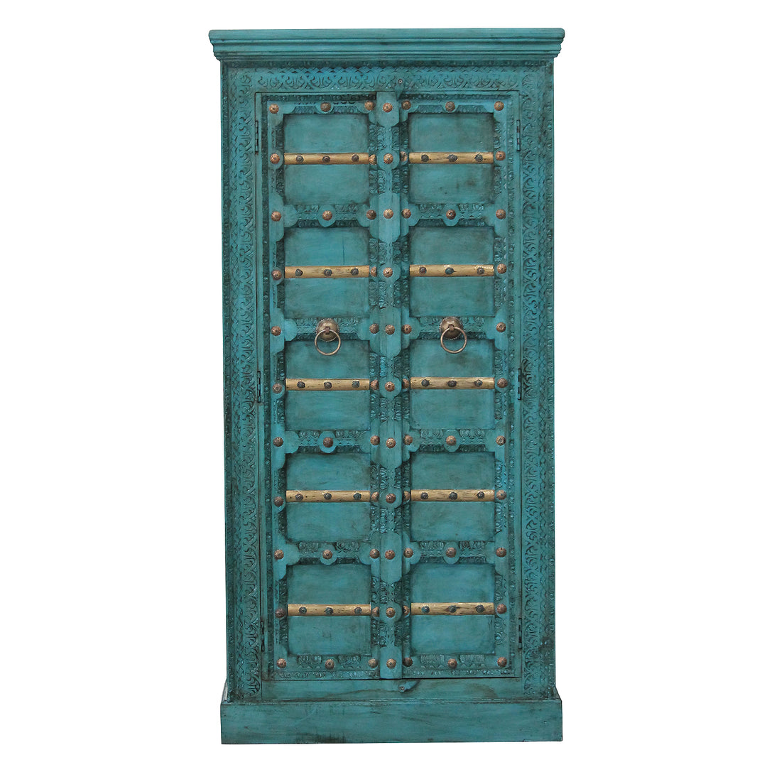 Front view of the turquoise mango wood cabinet, showing carved ornaments, gold-coloured trim and two doors.