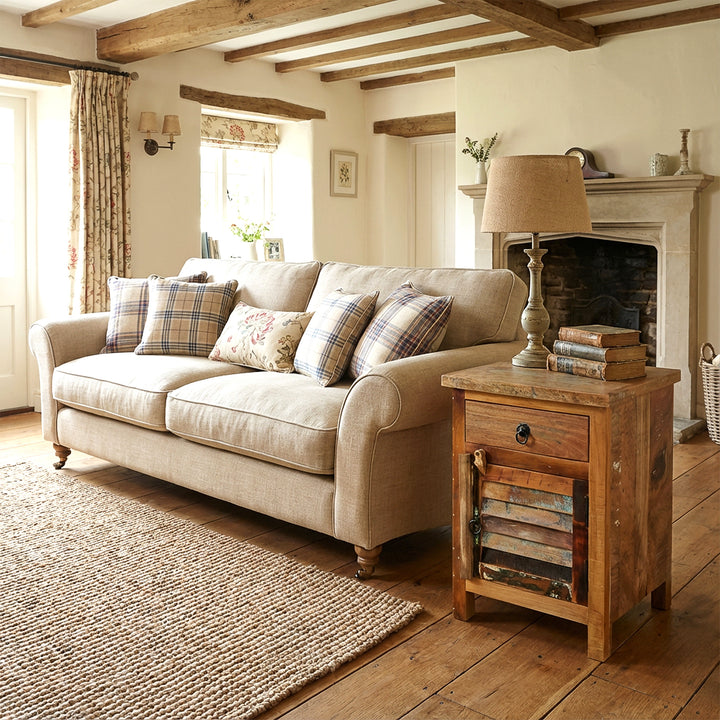 Wooden chest of drawers in the living room next to the sofa, warm country house atmosphere, natural light