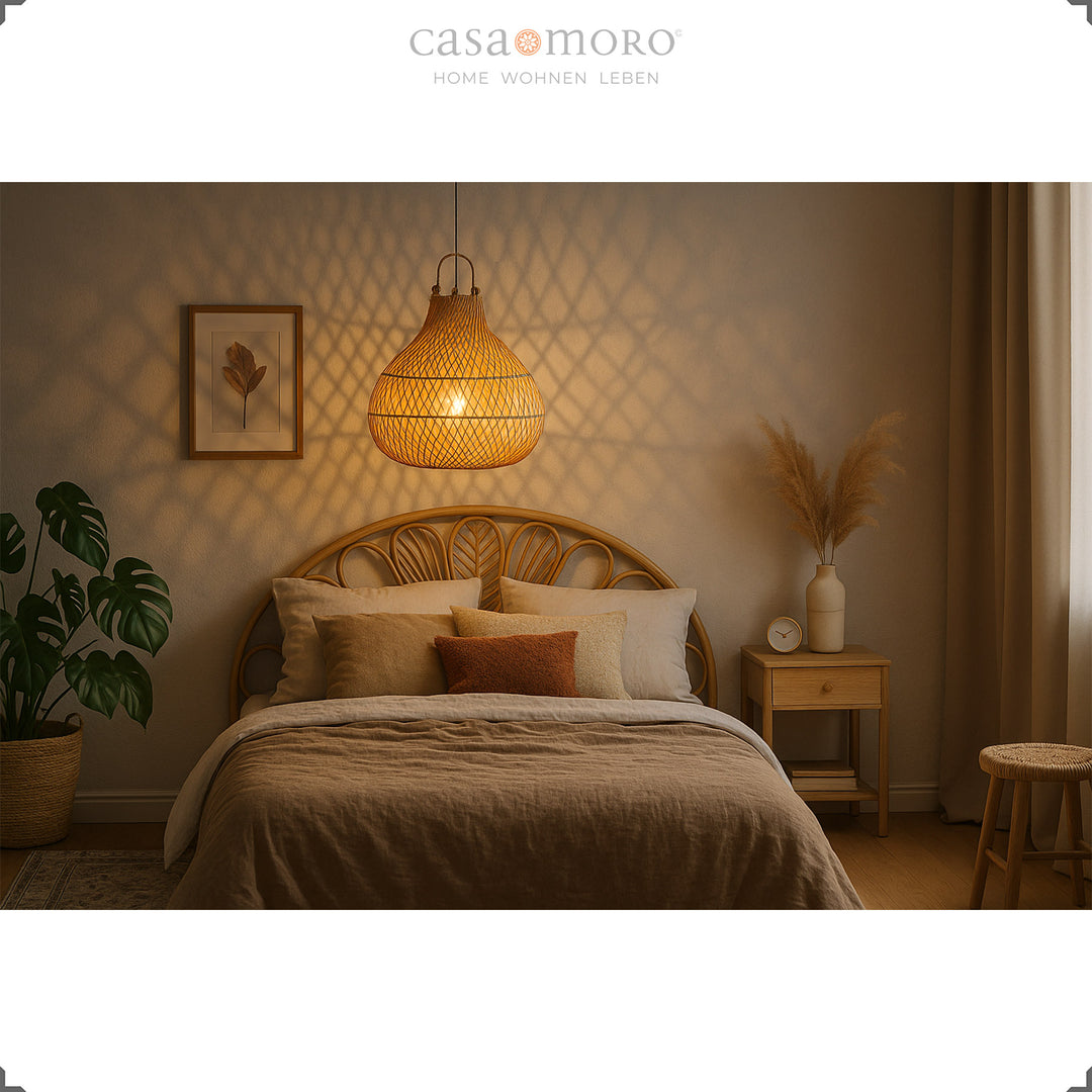 Rattan hanging lamp above bed in bedroom, warm light and natural furnishings