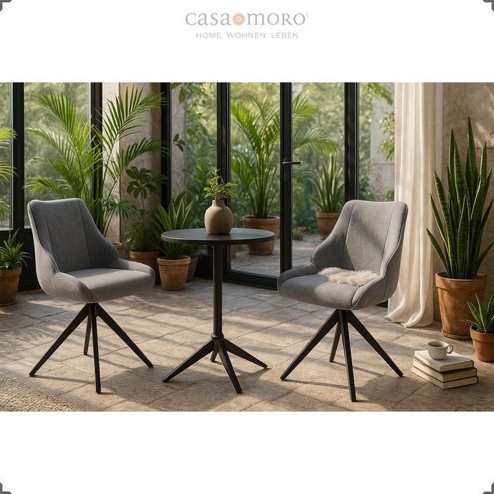 Two 360° swivel gray dining chairs with black metal frame arranged in winter garden with plants and natural light