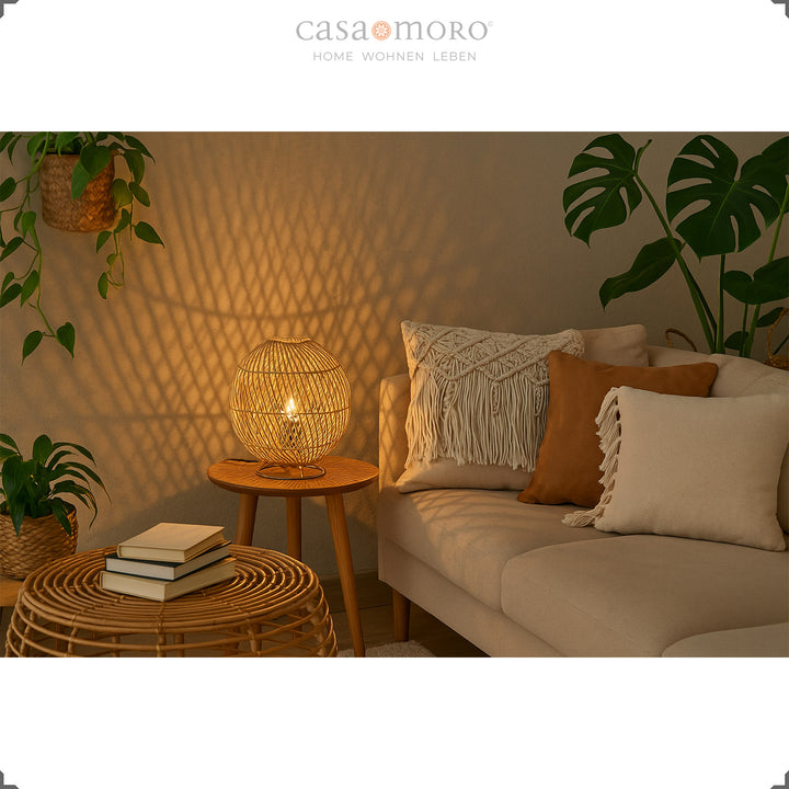 Round rattan lamp on side table in cozy living room with sofa corner and warm light