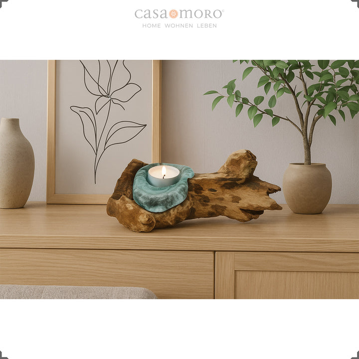 Tealight holder made of glass and burl wood on a sideboard, its warm light complements the natural, simple living room decoration.