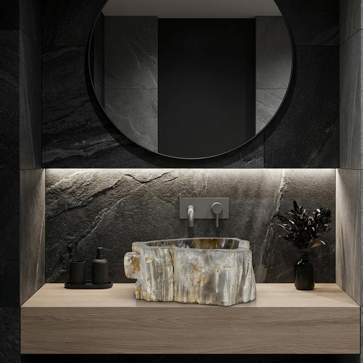 Washbasin made of stone as a countertop washbasin, modern bathroom ambience with dark natural stone tiles, clear lines and subtle lighting.